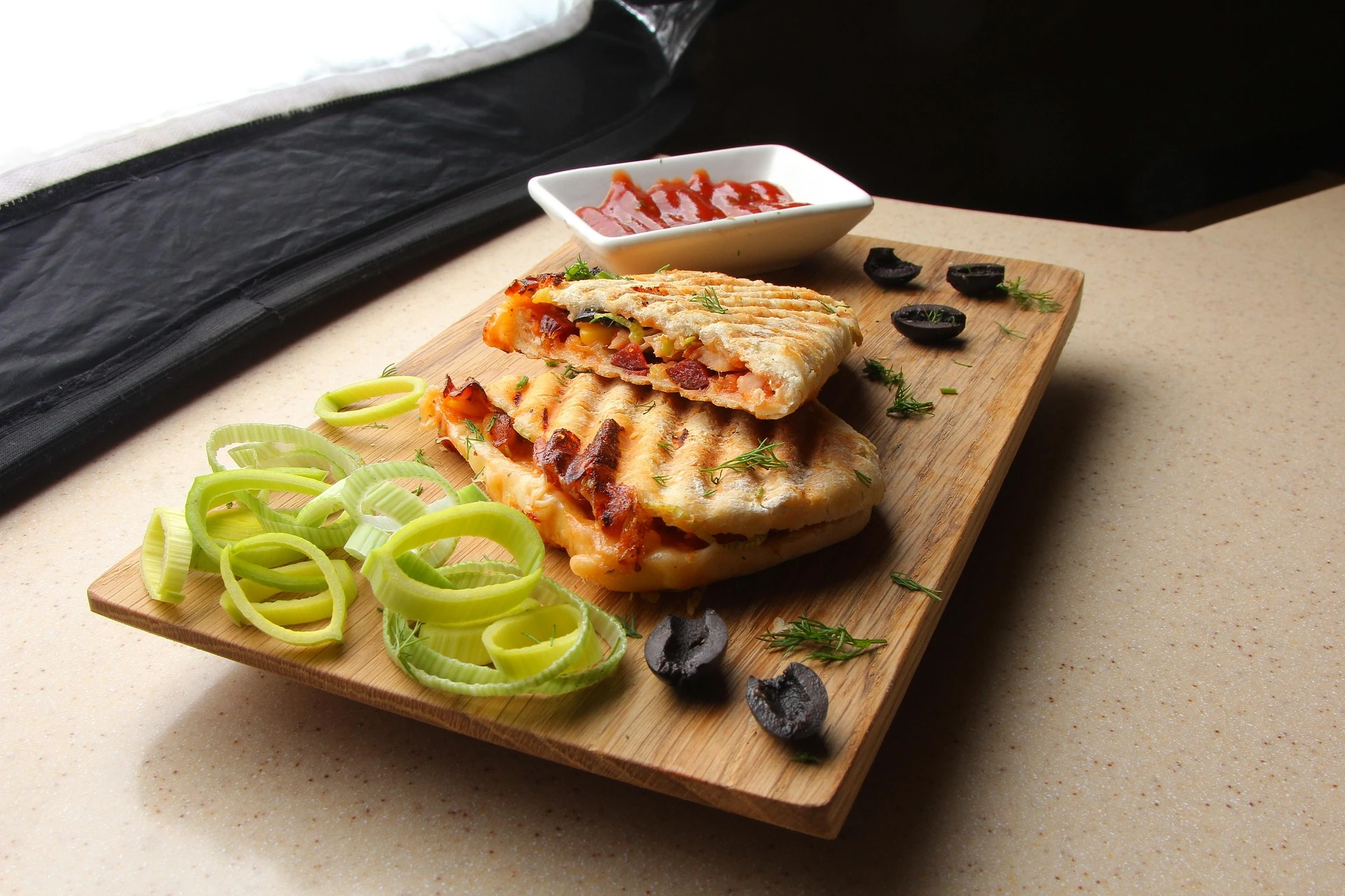 gros plan panini bacon et crudité sur une planche de bois
